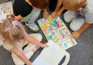 Dzieci oglądają książki w bibliotece.