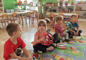 Dzieci wygrywają na instrumentach rytm podany przez nauczyciela.