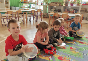 Dzieci wygrywają na instrumentach rytm podany przez nauczyciela.