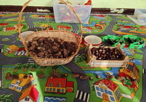 Dzieci układają rytmy ze zgromadzonych darów jesieni.