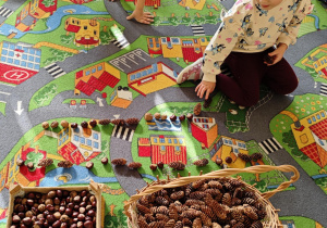 Dzieci układają rytmy ze zgromadzonych darów jesieni.