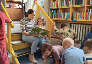 Pani czyta dzieciom książkę.