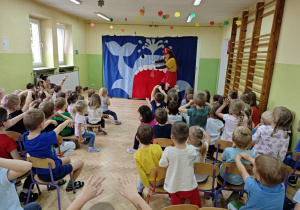 Dzieci oglądają i uczestniczą w przedstawieniu teatralnym "Pinokio".