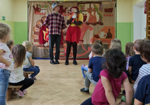 Dzieci oglądają i uczestniczą w przedstawieniu teatralnym "Pinokio".