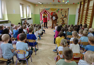 Dzieci oglądają i uczestniczą w przedstawieniu teatralnym "Pinokio".