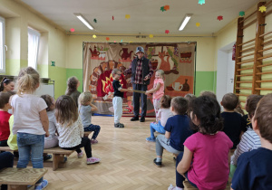 Dzieci oglądają i uczestniczą w przedstawieniu teatralnym "Pinokio".
