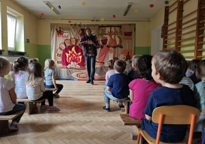 Dzieci oglądają i uczestniczą w przedstawieniu teatralnym "Pinokio".