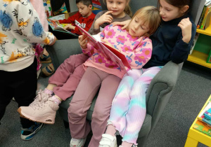 Dziewczynki czytają książkę.