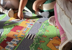 Dzieci doskonalą umiejętność przeliczania i porównywania długości wykorzystując sznurek z supełkiem.