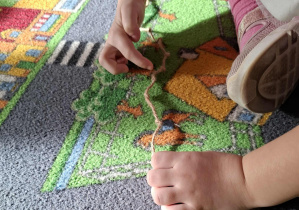 Dzieci doskonalą umiejętność przeliczania i porównywania długości wykorzystując sznurek z supełkiem.