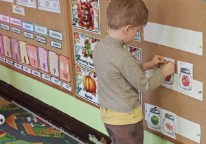 Dziecko przyczepia na tablicy emblematy wg opowieści nauczyciela - utrwala nazwy i pojęcia matematyczne.