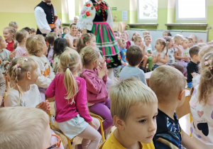 Dzieci witają przybyłych gości - tancerzy w strojach ludowych.