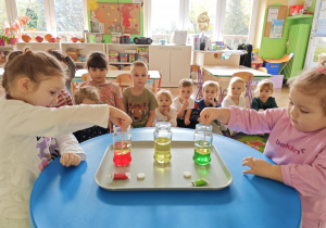Dzieci próbuja połączyć wodę z olejem.