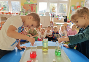 Dzieci mieszają barwnik z wodą.