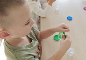 Dzieci bawią się "glutkiem", usprawniając przy tym swoje rączki.