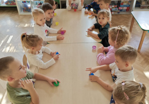 Dzieci bawią się "glutkiem", usprawniając przy tym swoje rączki.