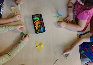 Dzieci łączą elementy, tworząc w ten sposób samolot.