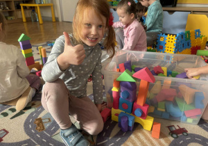 dziecko prezentuje budowlę z klocków