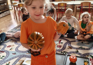 dziecko trzyma dynię w dłoni