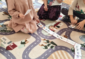 dziecko układa obrazki na dywanie