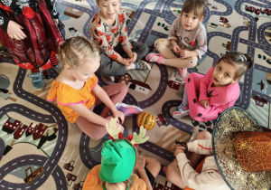 dzieci siedzą na dywanie