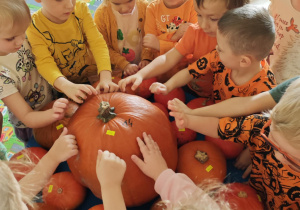 Dzieci sprawdzają odgłos jaki wydaje dynia.