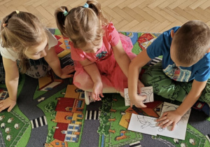 Dzieci układają dyniowe puzzle.