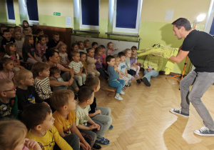 Aktor zbliża się zpacynką krokodyla do widowni.