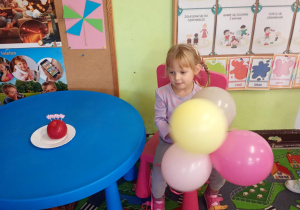 Dzieci siedzi z bukietem urodzinowych balonów.