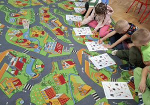 Dzieci wykonują zadania z karty pracy.