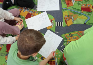 Dzieci wykonują zadania z karty pracy.