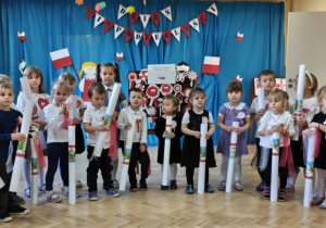 Dzieci biorące udział w przeglądzie "Patriotyczny kotylion" trzymają w rękach upominki.