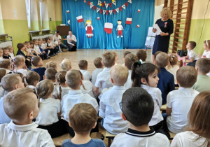 Dzieci rozwiązują zagadki dotyczące symboli narodowych Polski.