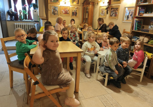 Dzieci siedzą i oczekują na przedstawienie.