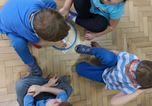 Dzieci w małych zespołach układają pocięte obrazki przedstawiające wybrane prawo.