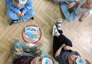 Dzieci w małych zespołach układają pocięte obrazki przedstawiające wybrane prawo.