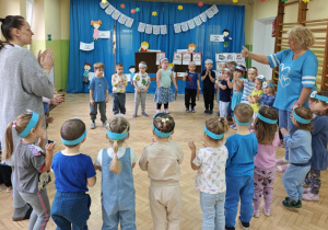 Dzieci ustawione w kole klaszczą podczas śpiewania refrenu piosenki "Dziecka prawa".