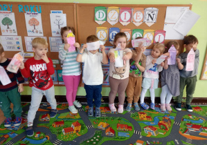 Dzieci pozują z pokolorowanymi szablonami kredek.