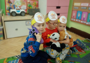 Dzieci przytulają się do misia.