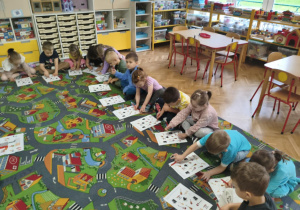 Dzieci wykonują zadanie na karcie pracy.