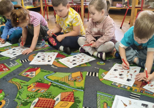 Dzieci wykonują zadanie na karcie pracy.