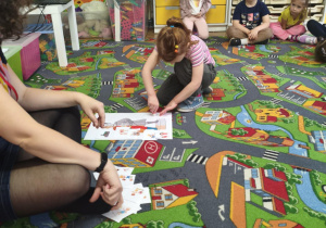 Dziewczynka przykleja obrazek.