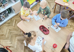 Dzieci wykonują pracę plastyczną.