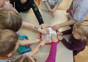 Dzieci poprzez dotyk doświadczają własciwości śniegu.