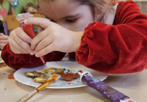 Dziewczynka ozdabia pierniczki.