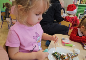 Dziewczynka ozdabia pierniczki.