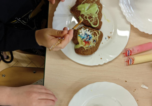 Dzieci ozdabiają pierniczki na świąteczny kiermasz.