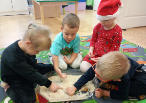 Dzieci w ryżu odwzorowują odszukane w nim figury geometryczne.