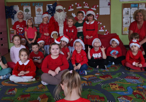 Dzieci pozują do zdjęcia z Mikołąjem.