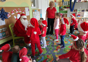 Dzieci rozmawiają z Mikołajem.